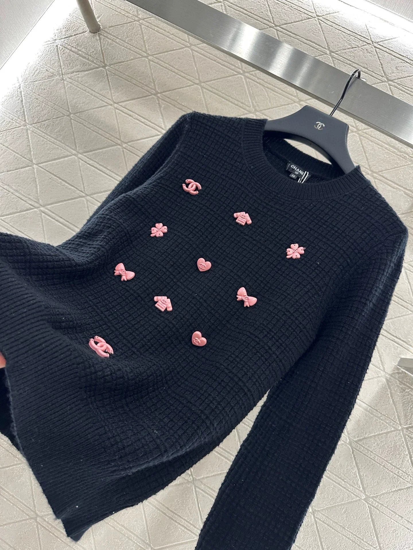 25 A simple logo sweater with a chain detail at the back waist.