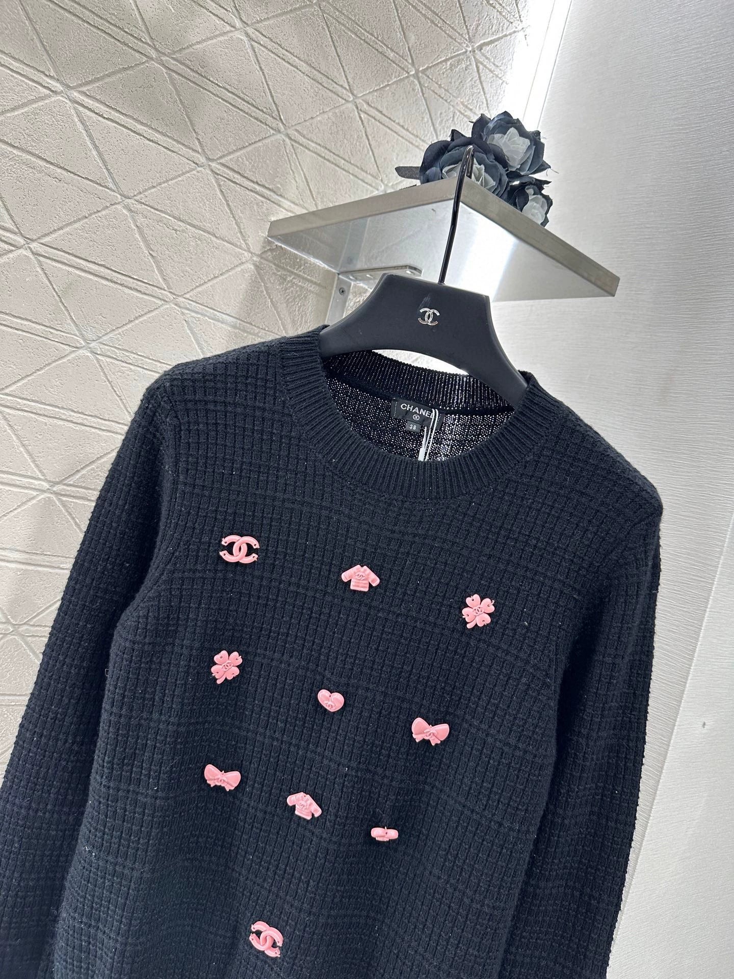 25 A simple logo sweater with a chain detail at the back waist.